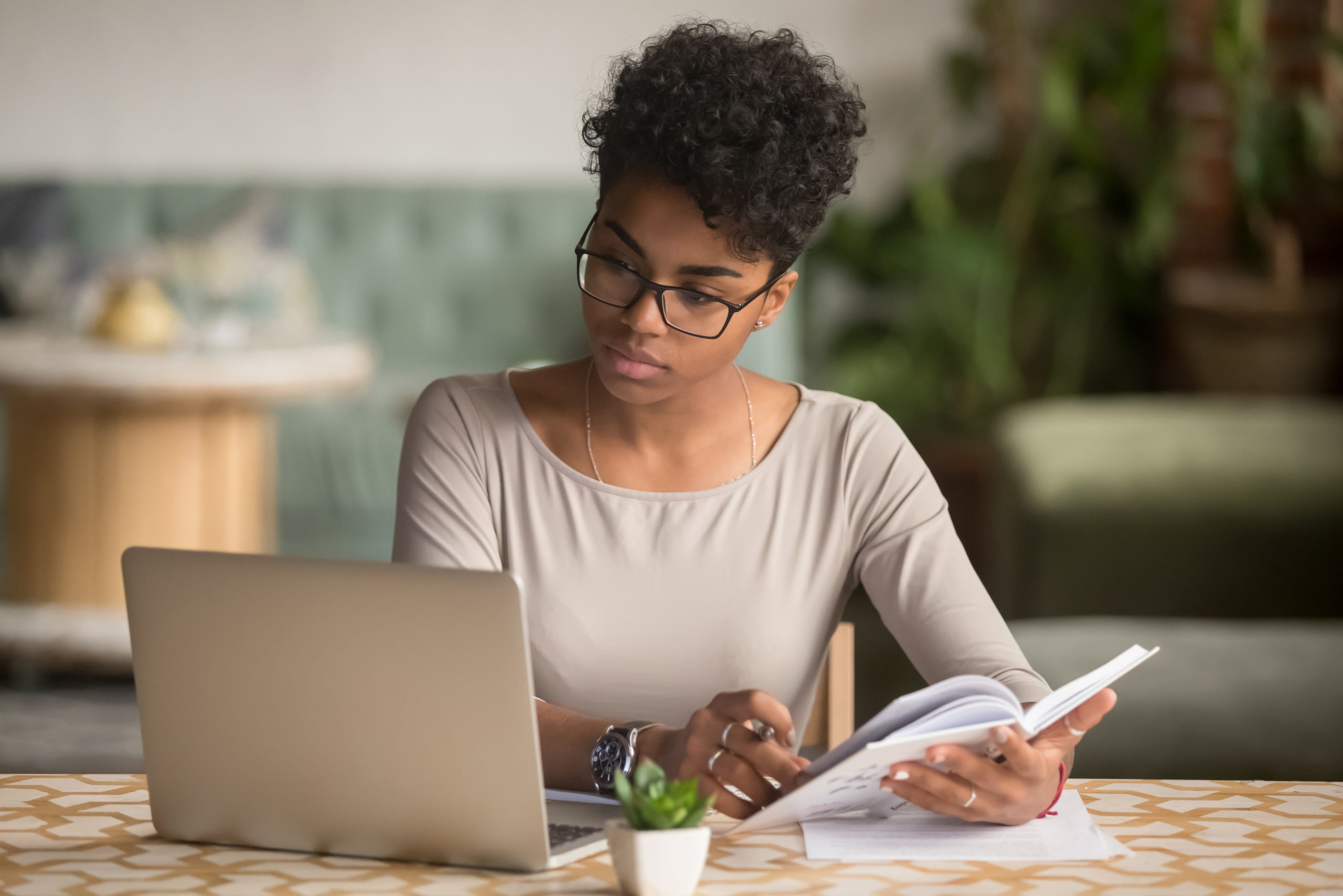 woman sitting at desk with a notebook and laptop