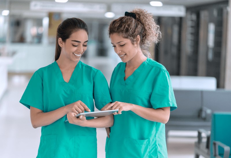 two healthcare workers reviewing a chart.