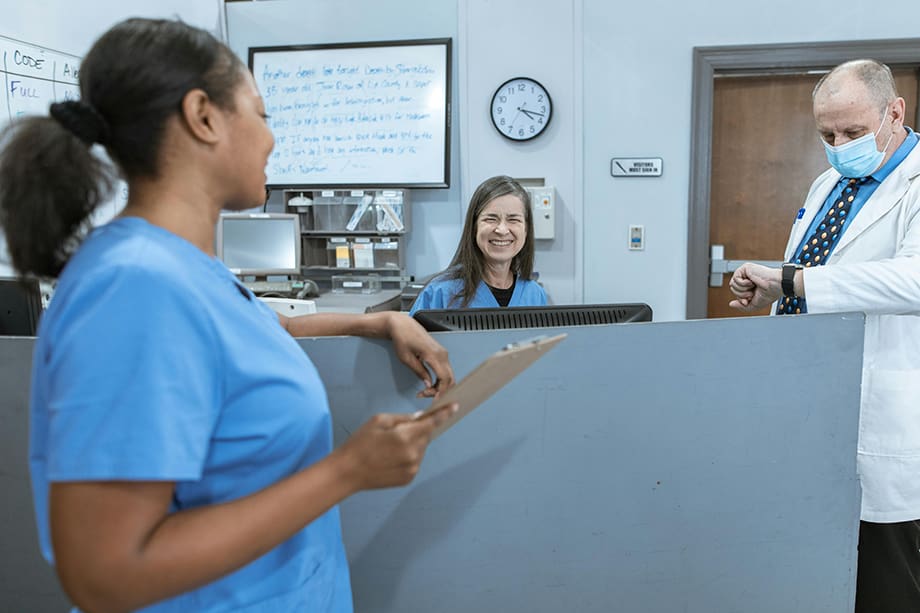 Women in scrubs smiling and talking in medical station