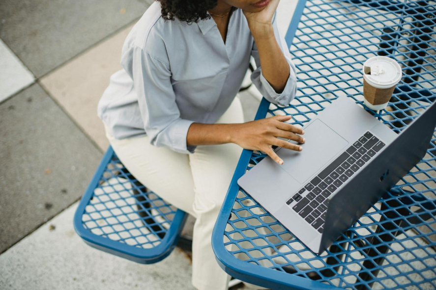 Woman using laptop on park picnic table