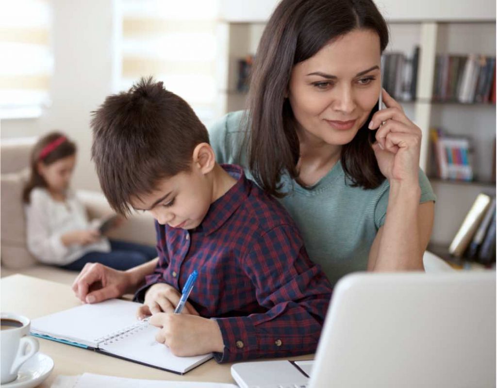 a mother with children in the background, she is researching and calling about mycaa